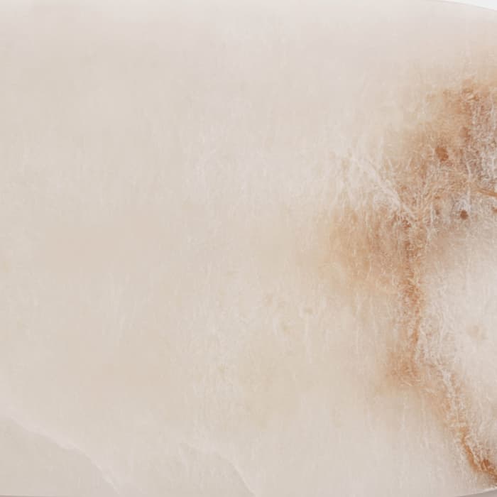 An elongated oval marble tray with shades of white and brown veining, placed on a plain white background.