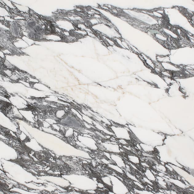 A circular marble tabletop with white and dark grey veining sits against a plain white background.